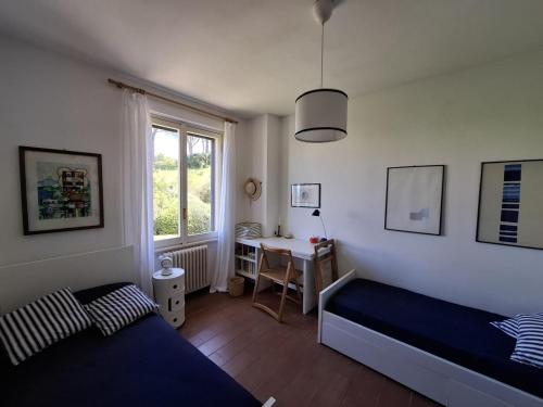 a bedroom with a bed and a desk and a window at Il Grifo - Cozy house, wonderful view in Portoferraio