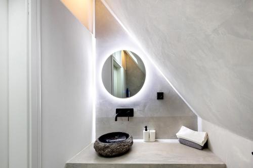 a bathroom with a round mirror and a sink at Penthouse Kokorey in Halstenbek