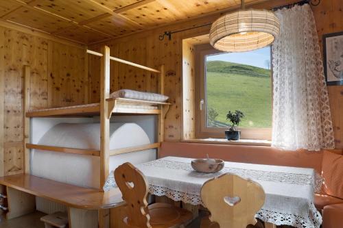 a room with a table and a bunk bed and a window at Apartment Rosengartenblick in Steinegg