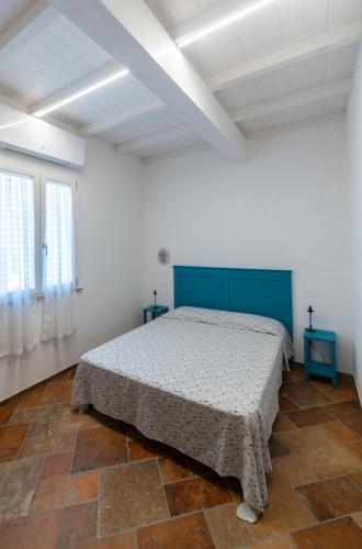 a bedroom with a bed in a white room at Il Rosmarino in Marciana