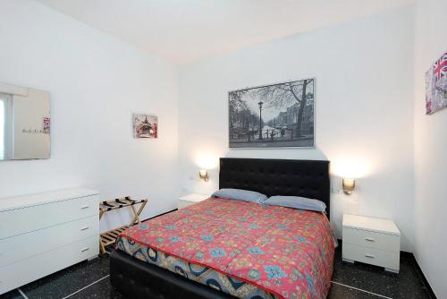 a bedroom with a bed with a red comforter at Il Corallo in Albisola Superiore