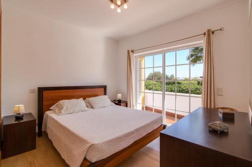 a bedroom with a bed and a large window at Villa do Lago in Albufeira