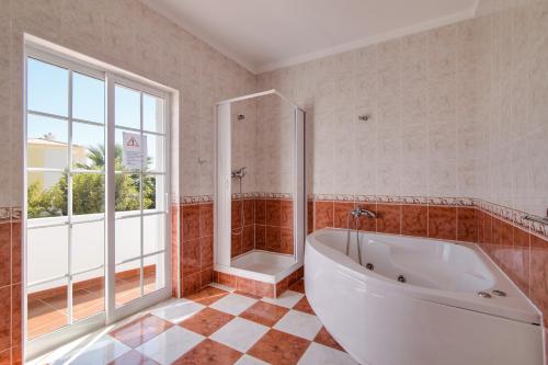 a large bathroom with a tub and a shower at Villa do Lago in Albufeira
