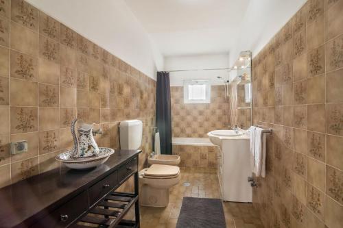 a bathroom with a toilet and a sink at Casa Guerreiro in Branqueira