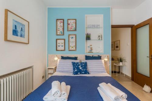 a bedroom with a blue and white bed with towels on it at La Terrazza in Brunate