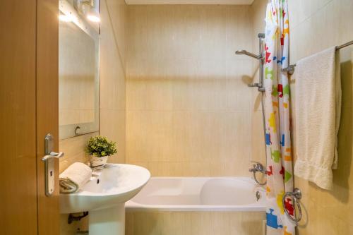 a bathroom with a sink and a bath tub at T2 Anastácio com vista Jardim in Olhos de Água