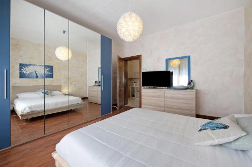 a bedroom with a large white bed and a television at Il ponte dei sogni in Brescia