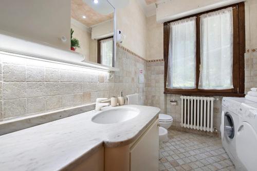 a bathroom with a sink and a washing machine at Il ponte dei sogni in Brescia
