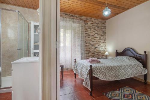 a bedroom with a bed and a walk in shower at A Casa d'Amália in Ginetes