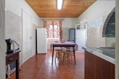 a kitchen with a table and a refrigerator at A Casa d'Amália in Ginetes