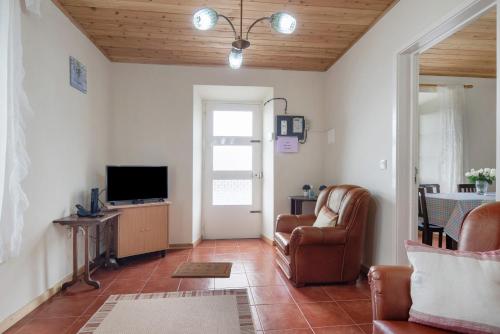 a living room with a couch and a television at A Casa d'Amália in Ginetes