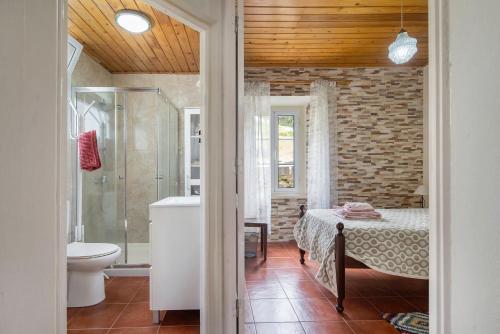 a bathroom with a bed and a shower and a toilet at A Casa d'Amália in Ginetes