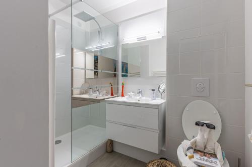 a white bathroom with two sinks and a glass shower at Studio cabine centre ville in Arcachon