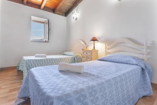 a bedroom with two beds with blue sheets and a window at Las Casas del Bisa in Garachico