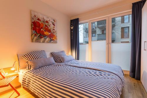 a bedroom with a bed and a large window at Ferienwohnung Büsumperle weiß in Büsum