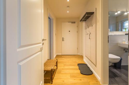 a hallway of a bathroom with a toilet and a sink at Ferienwohnung Büsumperle weiß in Büsum