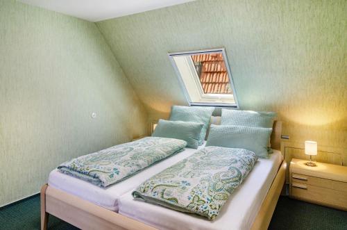 a bedroom with a bed with two pillows and a window at Ferienwohnung Inge in Uder