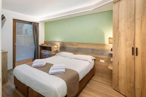 a bedroom with two beds and a green wall at Chalet Emma Isolaccia in Valdidentro