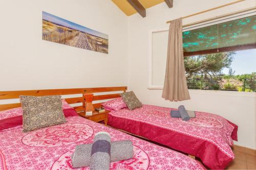 two beds in a room with a window at Buena Ventura Villa in Cala en Bosc