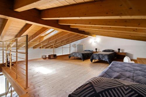 a attic bedroom with two beds and a staircase at Casa Zia Dani in Piantedo