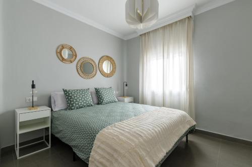 a bedroom with a bed and two mirrors on the wall at Málaga Dream Apartment in Málaga
