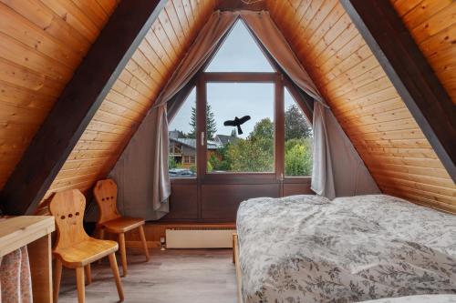 a bedroom with a bed and a large window at Ferienhaus Bussardnest in Tennenbronn