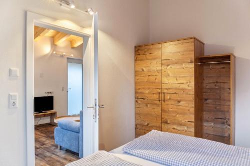 a bedroom with a bed and a wooden closet at Ferienwohnung Grubig in Ehrwald