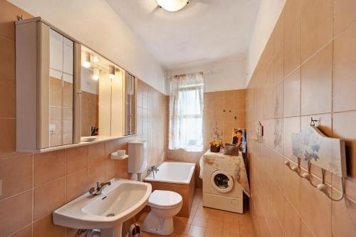 a bathroom with a sink toilet and a washing machine at Casa dei Fiori in Casanova Lerrore