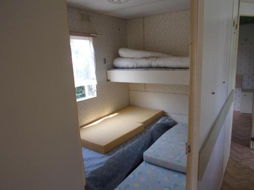 a small room with two bunk beds and a window at Mobil'Home du Sancillon in Charentay