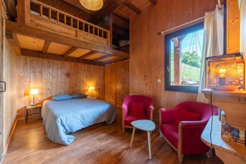 a bedroom with a bed and two chairs at L'Escampette à la Fontanette in Saint-Pancrace