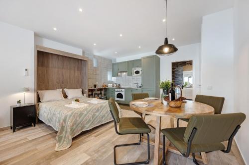 a bedroom with a bed and a table and a kitchen at Villa Xique 11 in Monchique