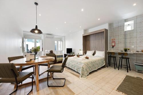 a bedroom with a bed and a table and a kitchen at Villa Xique 11 in Monchique
