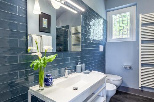 a blue bathroom with a sink and a toilet at Casa Lu in Massarosa