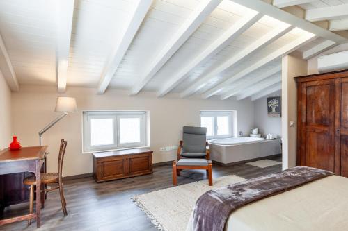 a bedroom with a bed and a desk and a tub at Casa Lu in Massarosa