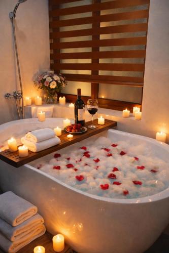 a bath tub with candles and a bottle of wine at Mie's Homestay in Danang
