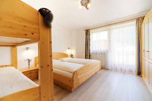 a bedroom with two bunk beds and a large window at Leitnerhof in Racines
