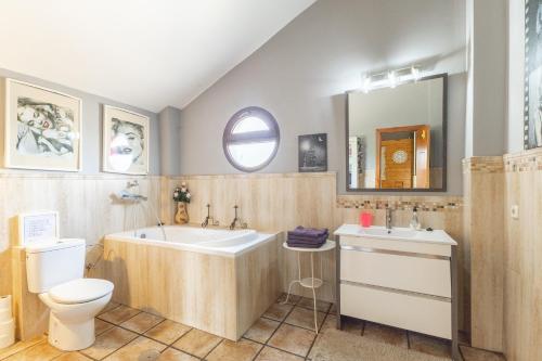 a bathroom with a tub and a toilet and a sink at El Berrueco in El Berrueco