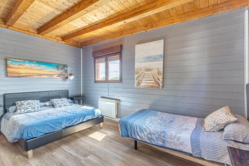 a bedroom with two beds and a wooden ceiling at El Berrueco in El Berrueco