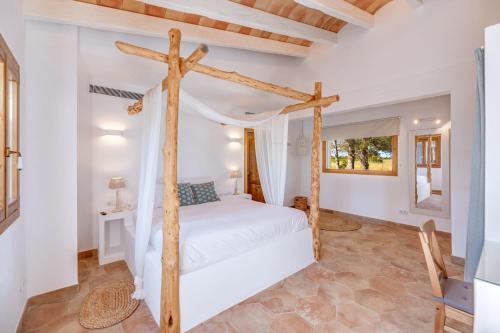 a bedroom with a bed and a wooden cross at Sa Vinya Jove in Biniali