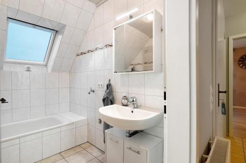 a white bathroom with a sink and a bath tub at Ferienwohnung Abendsonne in Lehe