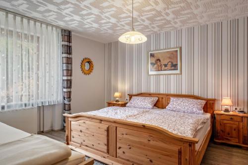 a bedroom with a large wooden bed and a ceiling at Haus Marianne Duffner in Schonach