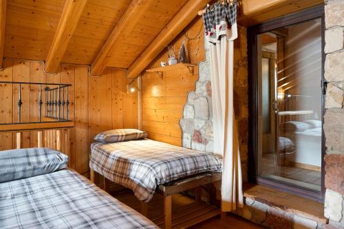 a room with two beds in a log cabin at Baita Chalet Alabama in Arsiè