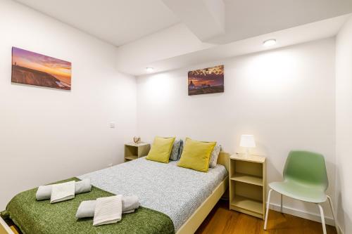 a bedroom with a bed and a chair at Fração D'ouro By Sesimbra in Sesimbra