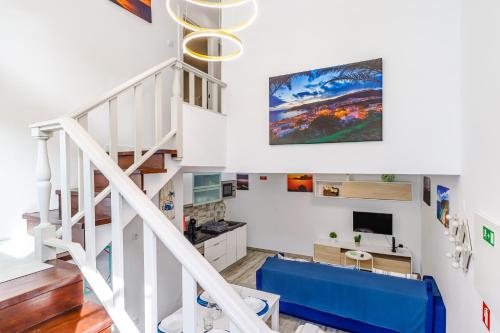 a white staircase with a blue couch in a living room at Fração D'ouro By Sesimbra in Sesimbra