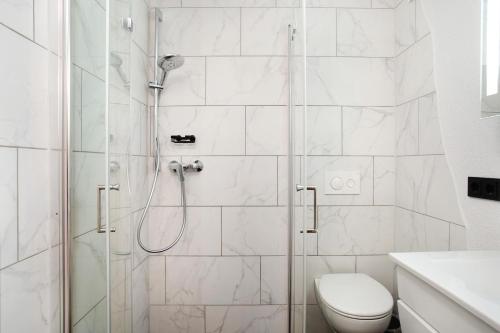 a white bathroom with a shower and a toilet at Carpe Diem in Altshausen