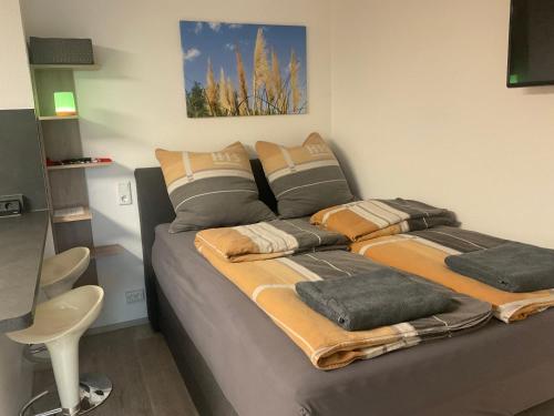 a bed with blankets and pillows on it in a room at Carpe Diem in Altshausen