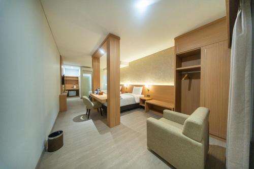 a hotel room with a bed and a desk at Horison IJ Kudus in Kudus