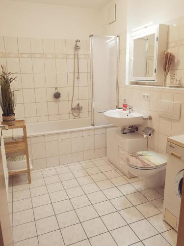 a bathroom with a sink and a tub and a toilet at Ostseeperle Karlina in Karlshagen