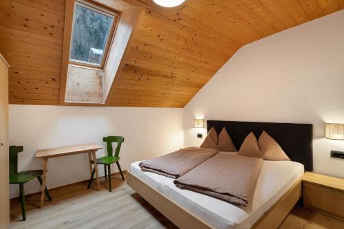 a bedroom with a bed and a wooden ceiling at Pfaffingerhof Antholz in Masserie