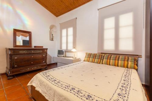 a bedroom with a bed and a dresser and a mirror at Maresme Natura in Sant Iscle de Vallalta